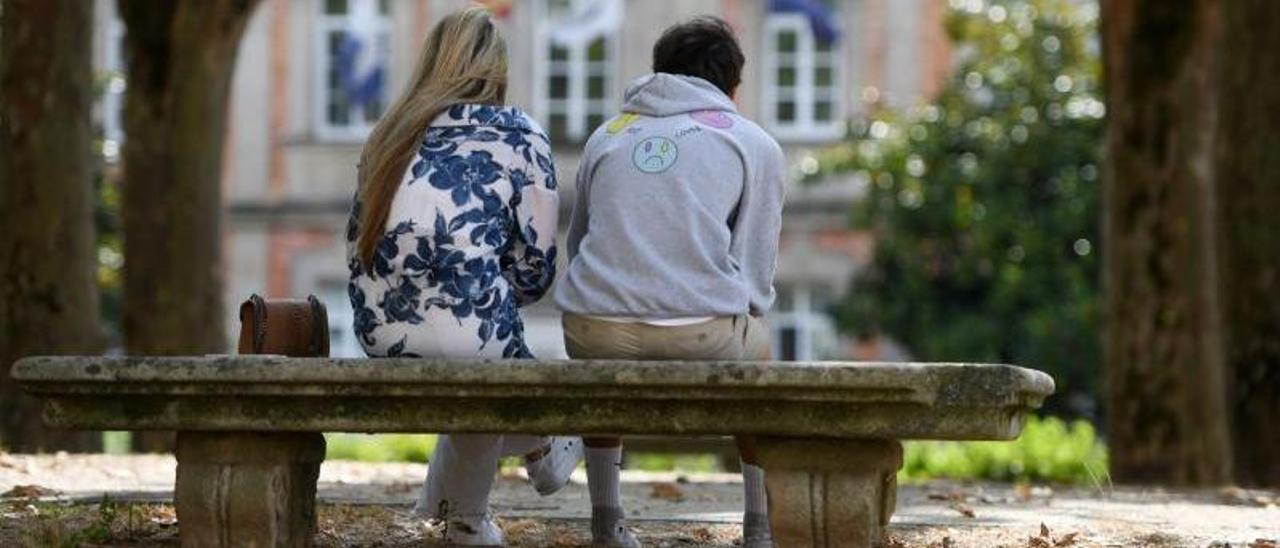 Una pareja pontevedresa en la Alameda, frente al Pazo de la Diputación provincial de Pontevedra.