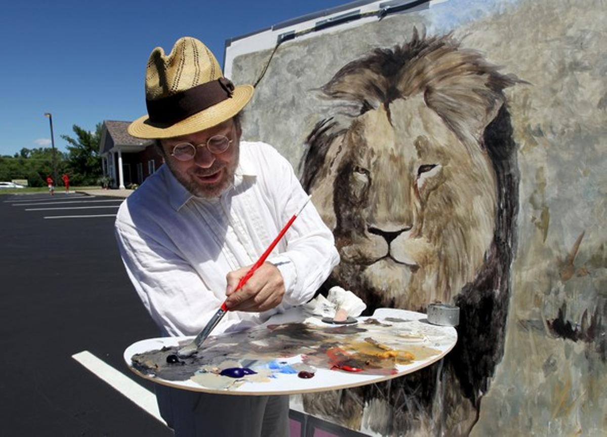 L’artista californià Mark Balma pinta Cecil davant la clínica del dentista Walter James Palmer, aquest dimecres.