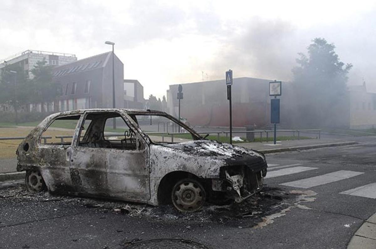 Un cotxe apareix cremat desrpés dels enfrontaments entre joves i policies a Amiens (França). 16 agents van resultar ferits.