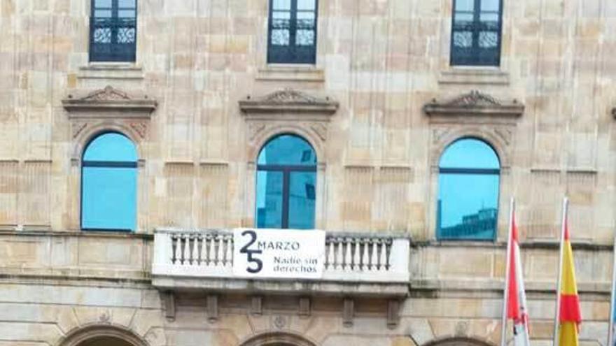 Mario Suárez del Fueyo, en la plaza Mayor, con la pancarta colocada en el balcón de la Casa Consistorial.