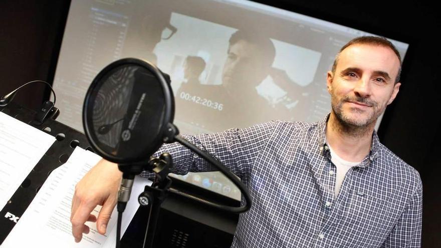 El doblador Claudio Serrano en un estudio de Gijón, frente a una imagen de Ben Affleck, uno de sus personajes.