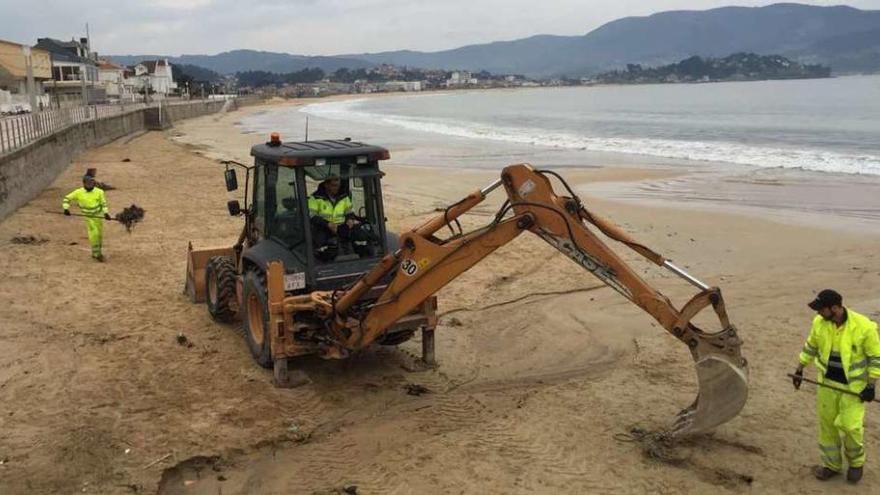 Labores de limpieza por parte de operarios municipales y de Cespa, ayer, en la playa de Panxón.