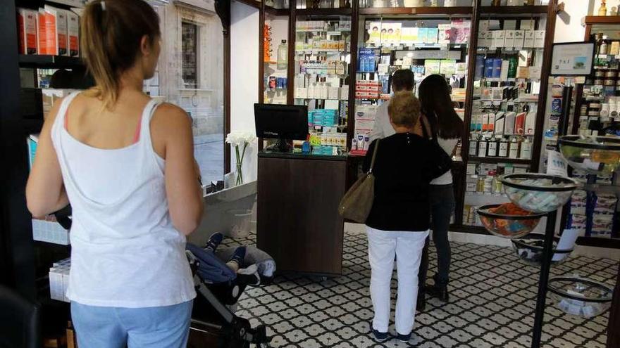 Varios clientes compran en una farmacia de la capital zamorana.