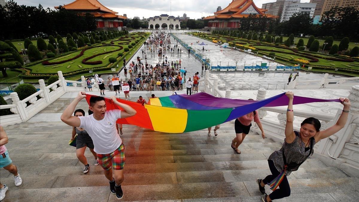  Miembros de la comunidad LGBT hacen ondear una bandera arcoirís durante una marcha en Chiang Kai-shek, Taipei, Taiwán.