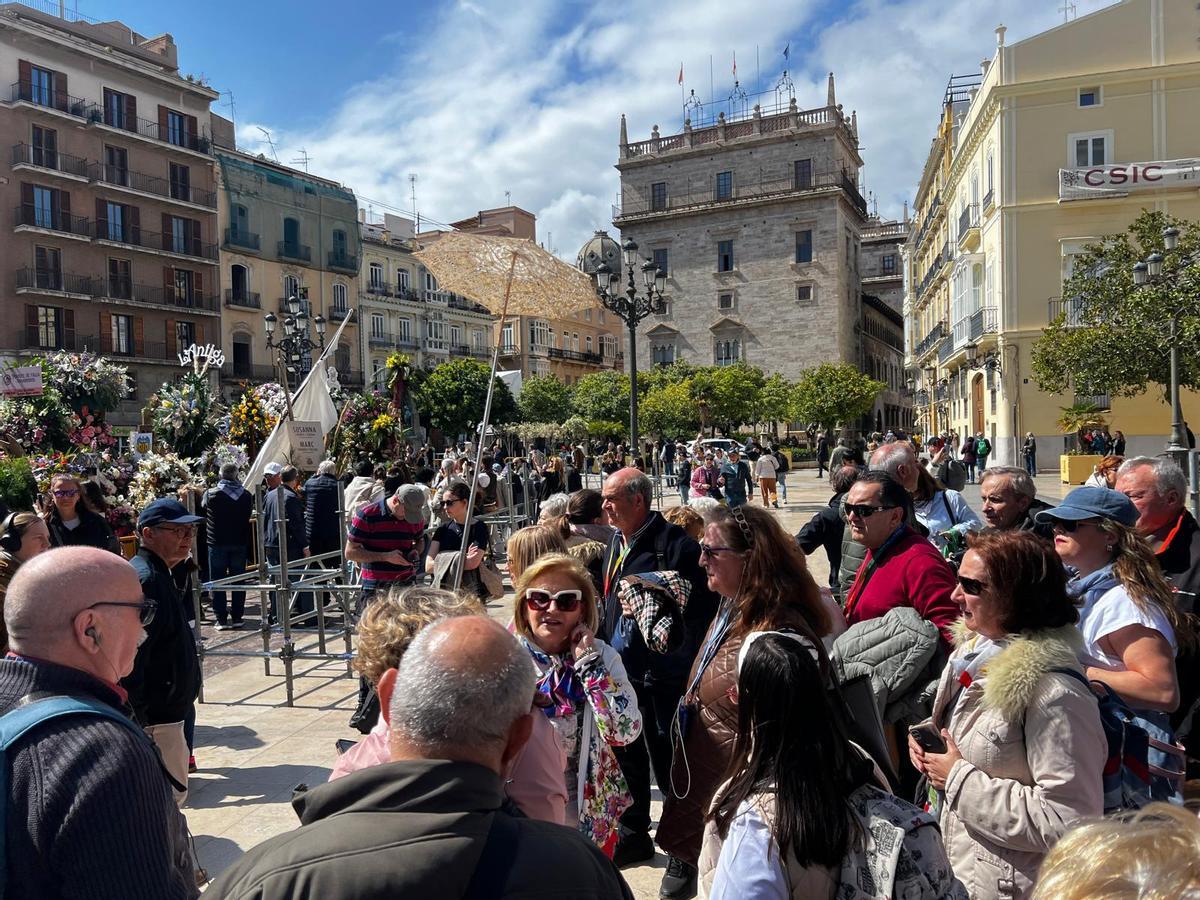 Una guía explicando los pormenores de la Ofrenda a turistas