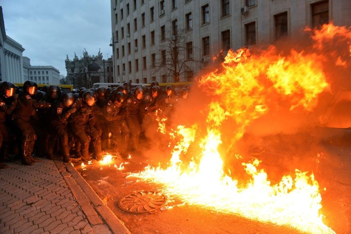 Un cóctel molotov explota frente al muro policial que evita la entrada de los manifestantes en el edificio de administración de la presidencia.