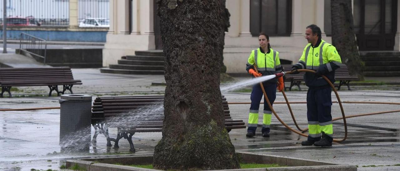 Dos trabajadores limpian una
zona de A Coruña.   | //  V. ECHAVE
