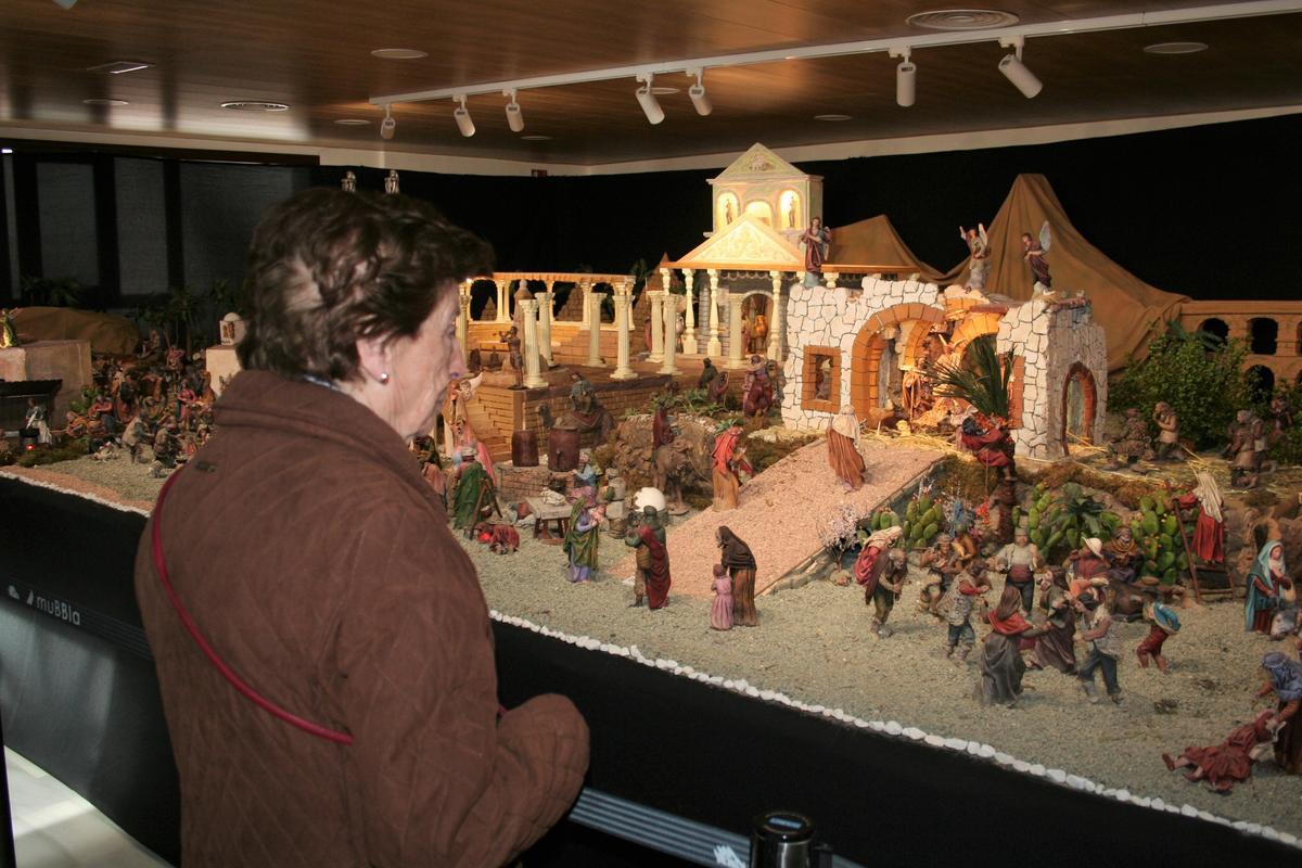 Una visitante contempla el portal de Belén con el Niño Jesús recién nacido.