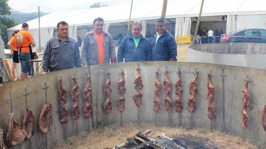 Los asadores vigilan los corderos en el prado de la fiesta.