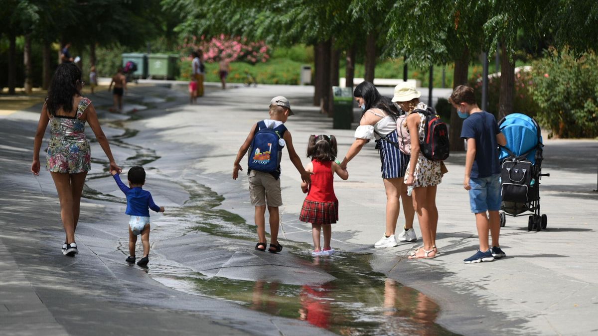 Varios niños pasan por un arroyo de agua.
