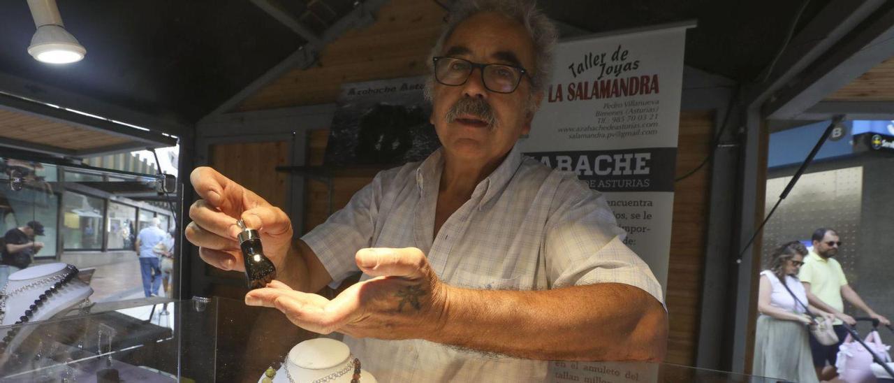 El artesano Pedro Villanueva posa con unas manitas en el Mercado del Azabache, que abrió ayer su segunda edición. | |  LUISMA MURIAS