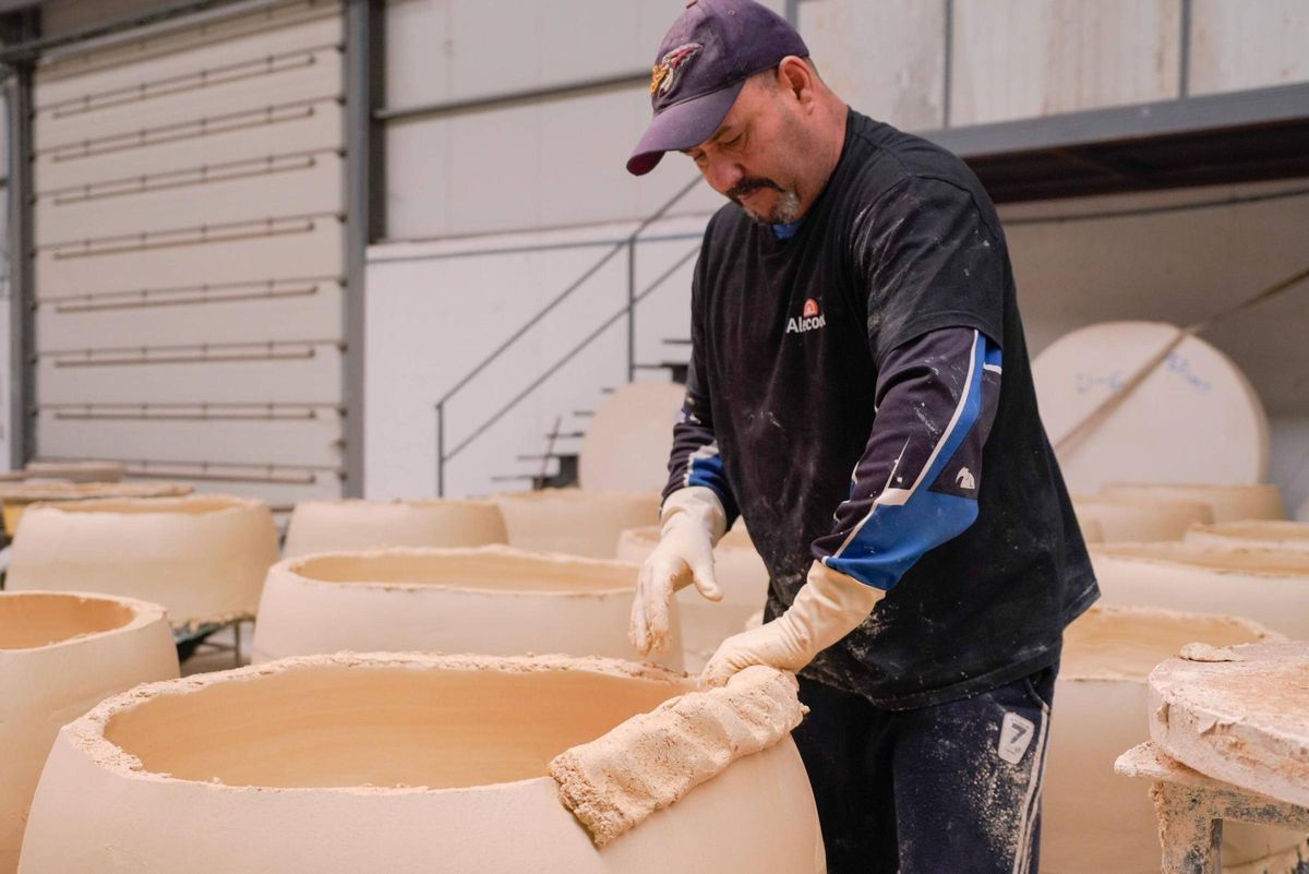 Un empleado de la empresa da forma al interior de un horno de leña.