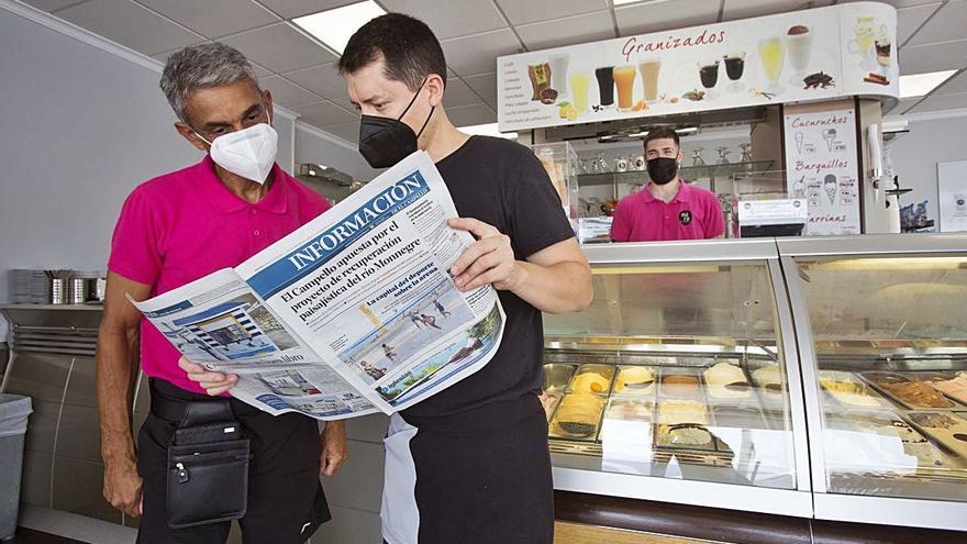 Dos lectores comentan  en una heladería de El Campello la nueva edición del periódico.