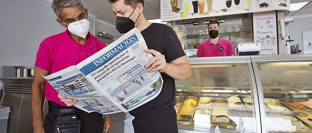 Dos lectores comentan  en una heladería de El Campello la nueva edición del periódico