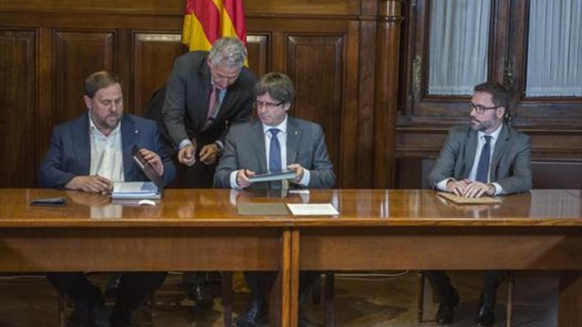 Oriol Junqueras y Carles Puigdemont firman el decreto de convocatoria del referéndum, anteayer.