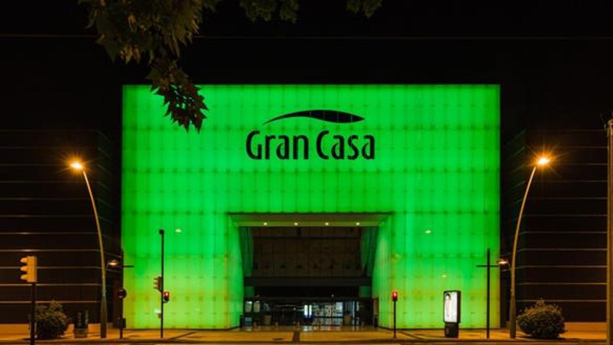 Fachada de GranCasa iluminada de verde