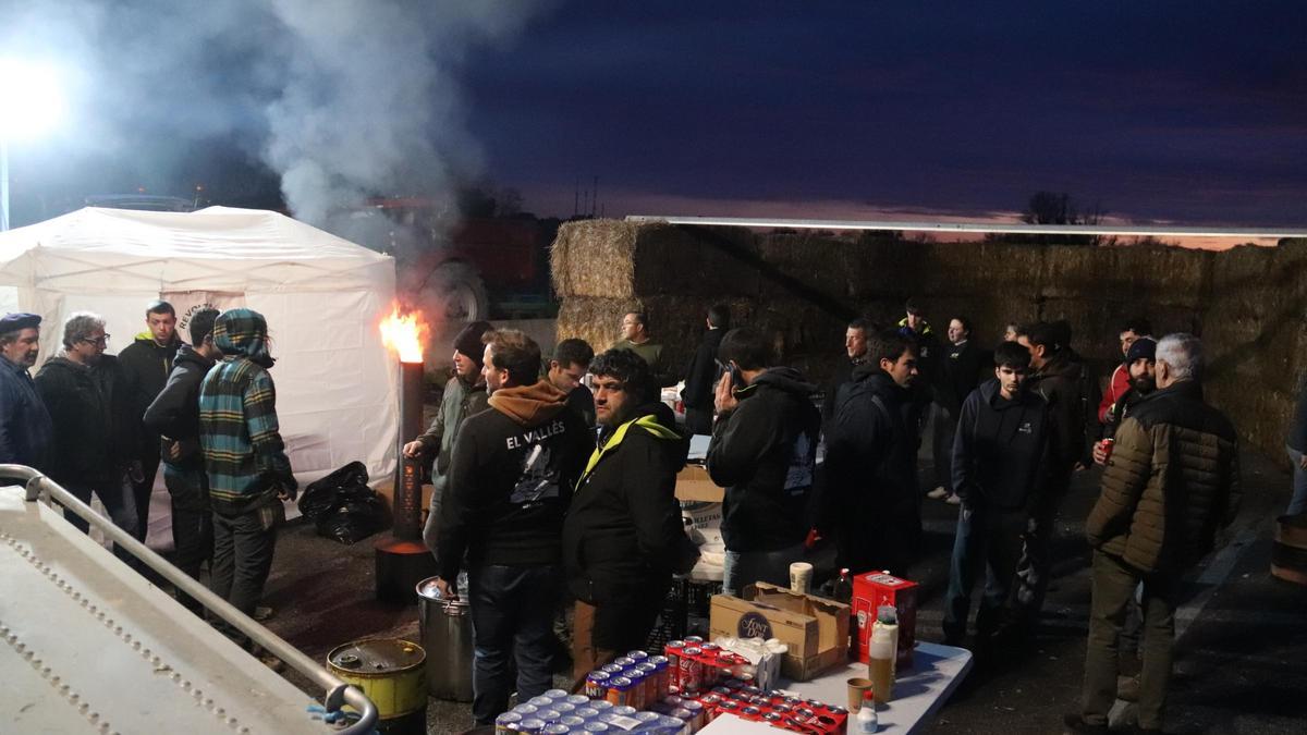 Alguns pagesos es preparen per passar la nit a l'AP-7 amb una estufa d'oli i generadors