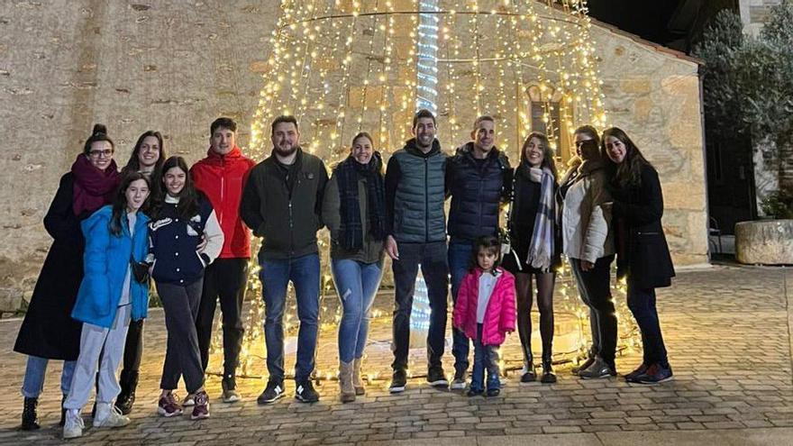 Un grupo de jóvenes encargados de la elaboración de parte de la decoración navideña en Trabazos. Abajo, encendido por las calles y el Belén montado en la iglesia de San Pelayo Mártir.  | CH. S.