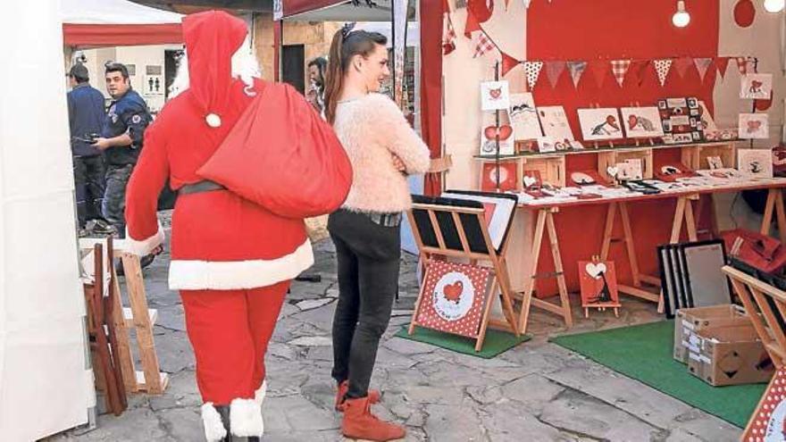 Un Papá Noel visita el mercadillo del Pueblo Español.