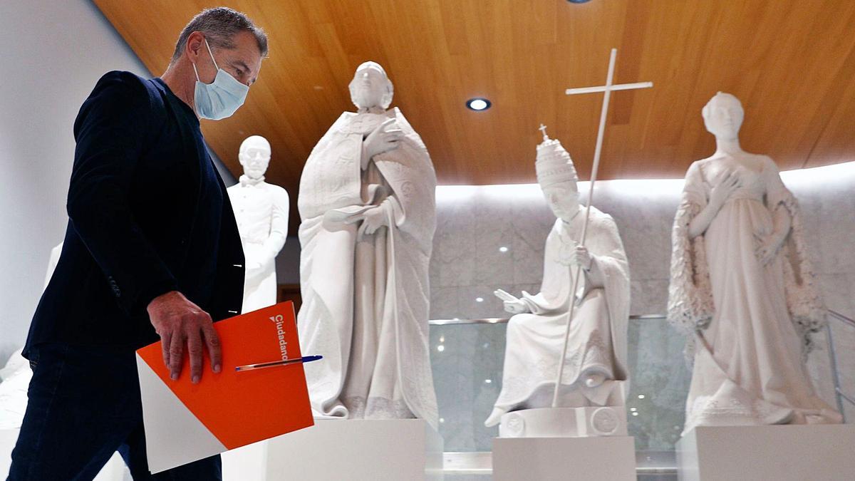 Toni Cantó, con una carpeta de Ciudadanos, pasa ante las estatuas de la familia Borja en las instalaciones de las Corts Valencianes. | LEVANTE-EMV