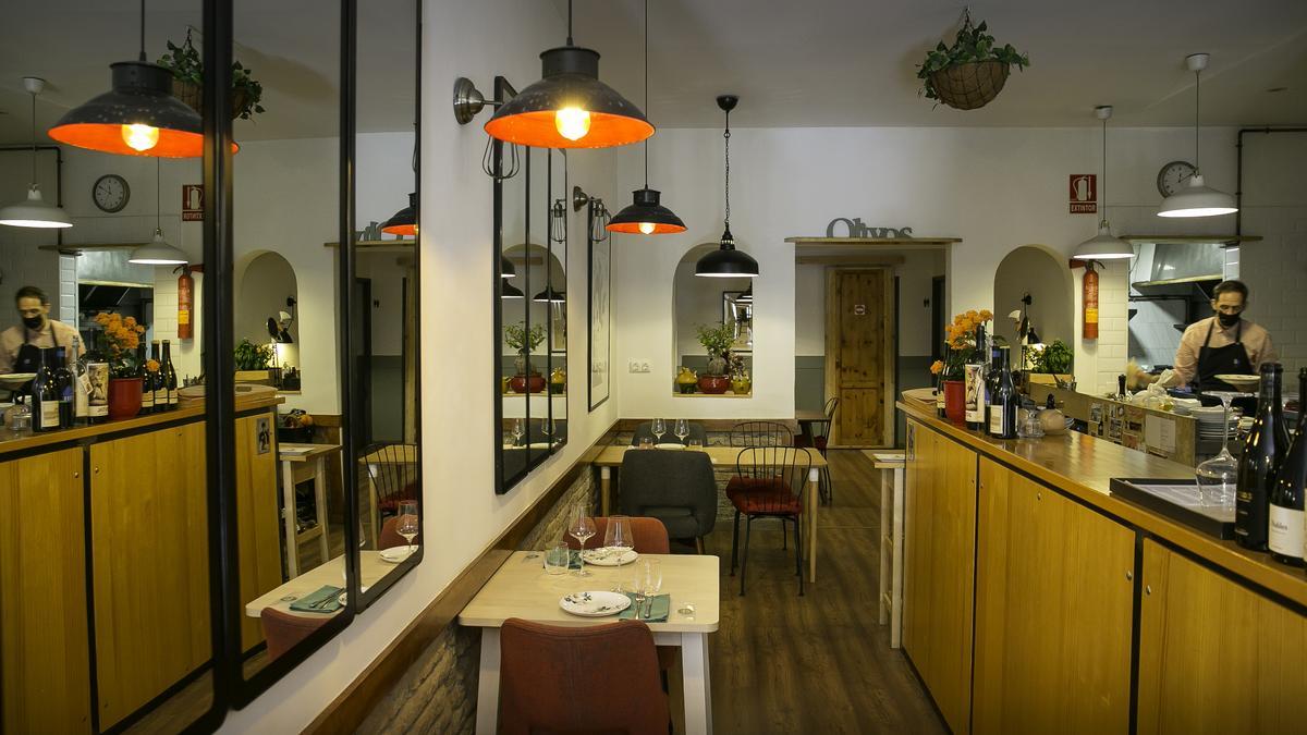 La sala, con la cocina abierta, del restaurante Olivos.