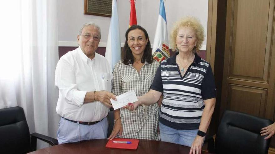 Diego Murillo entrega el cheque a la representante de San Vicente Paul en presencia de la alcaldesa. // S.A