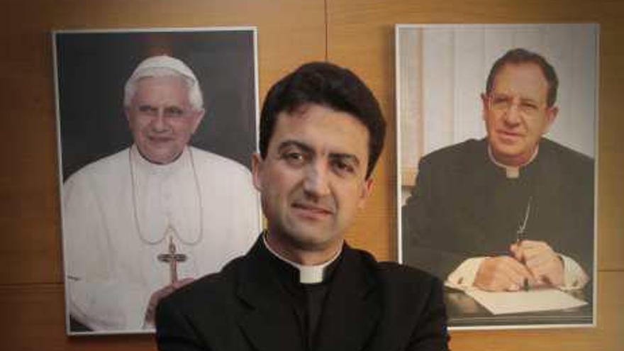 El sacerdote, ayer, entre los retratos del Papa y el obispo.