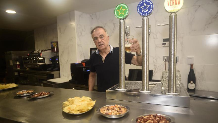 Juan José Vives, sirviendo una caña en la nueva barra del local.