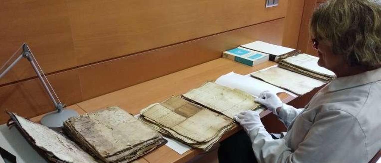 Una empleada del archivo, con algunos de los documentos que se restaurarán.