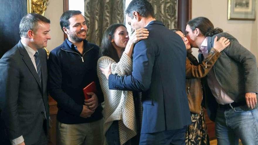 Pedro Sánchez abraza a Irene Montero y Pablo Iglesias besa a Adriana Lastra tras la firma del preacuerdo, con el jefe de gabinete, Iván Redondo, y Alberto Garzón a la izquierda.