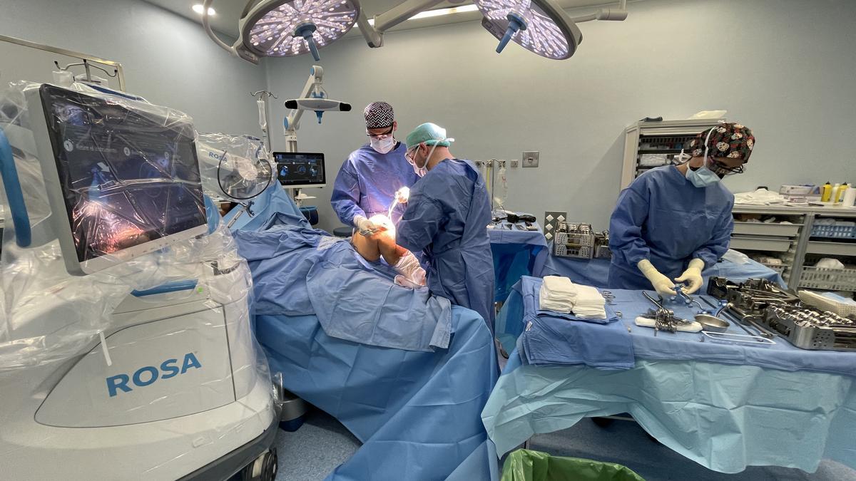Cirujanos trabajando en la prótesis con la ayuda del robot ROSA