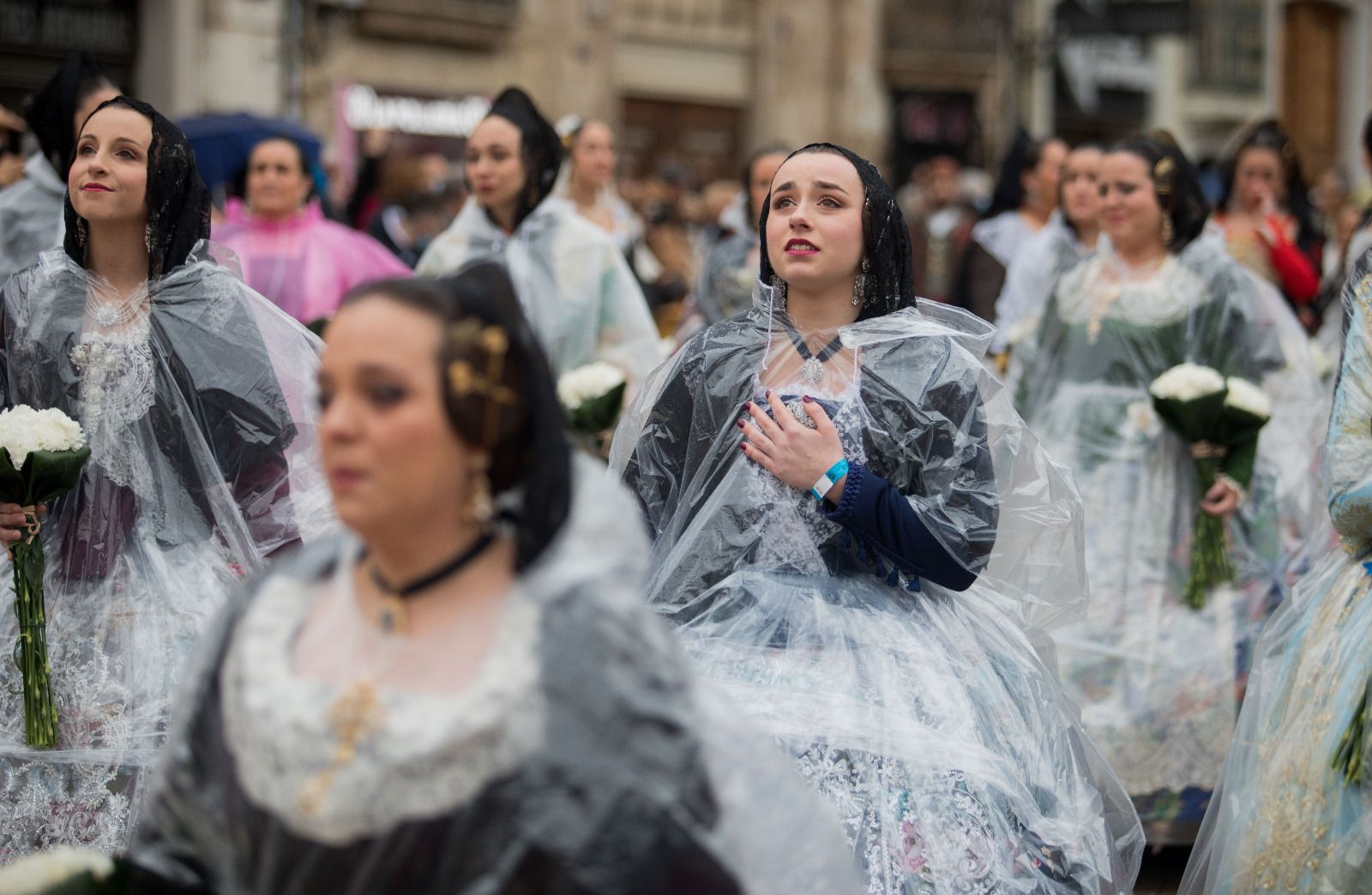 Desfile de chubasqueros y paraguas ante la Mare de Déu