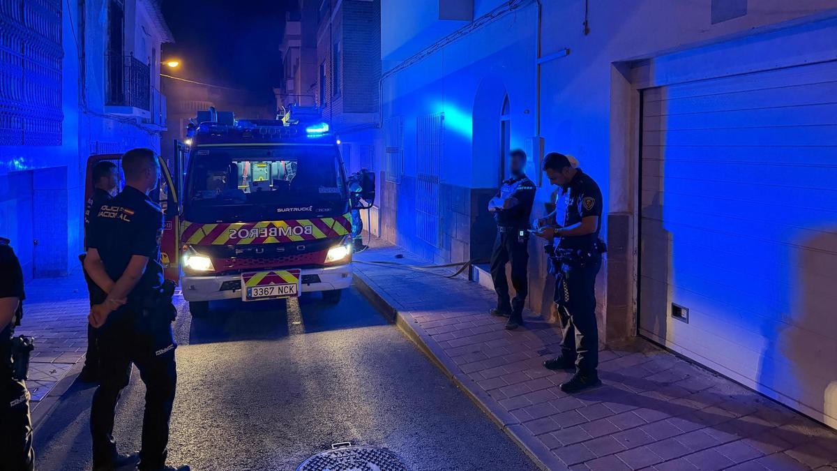 Policías y bomberos, en el lugar del incendio de la vivienda en Lorca, de madrugada.