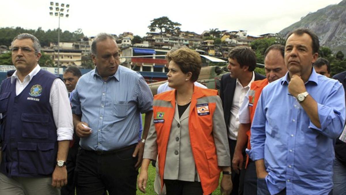 La presidenta de Brasil, Dilma Rousseff, visita, junto al gobernador del estado de Río de Janeiro, Sergio Cabral (derecha) y otras autoridades locales, los daños causados por las inundaciones en la ciudad de Friburgo, el jueves.