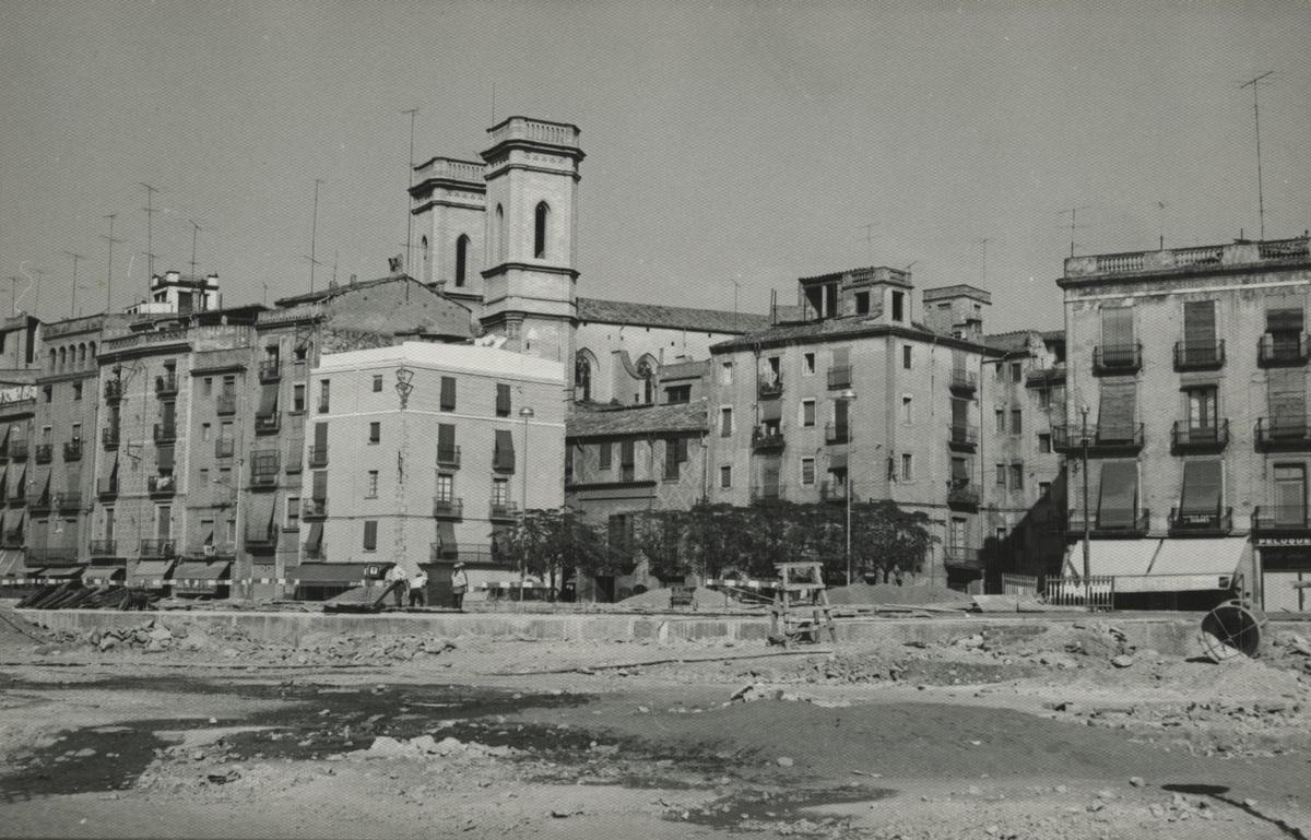 Obres per a la construcció de la plaça Catalunya sobre el riu Onyar. S'observa la rambla Verdaguer i les torres del Sagrat Cor.