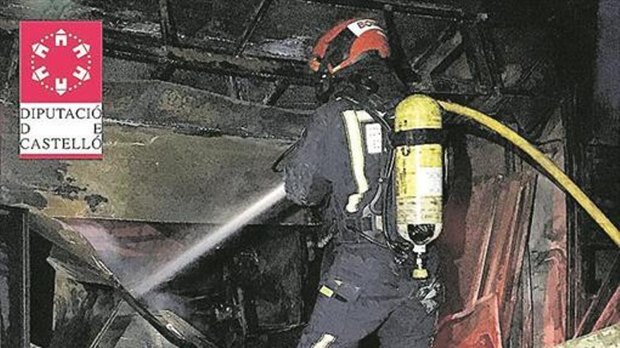 Un incendio devora un taller de coches y amenaza una nave fallera