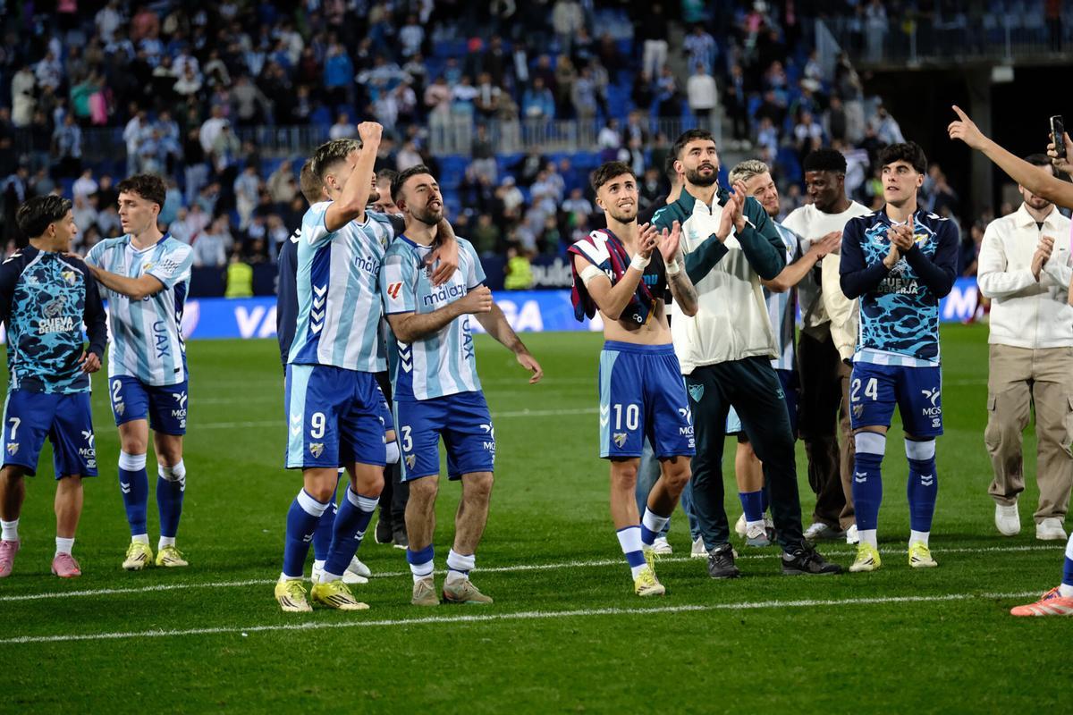 Los jugadores del Málaga CF celebran con la grada de animación la victoria ante la SD Huesca