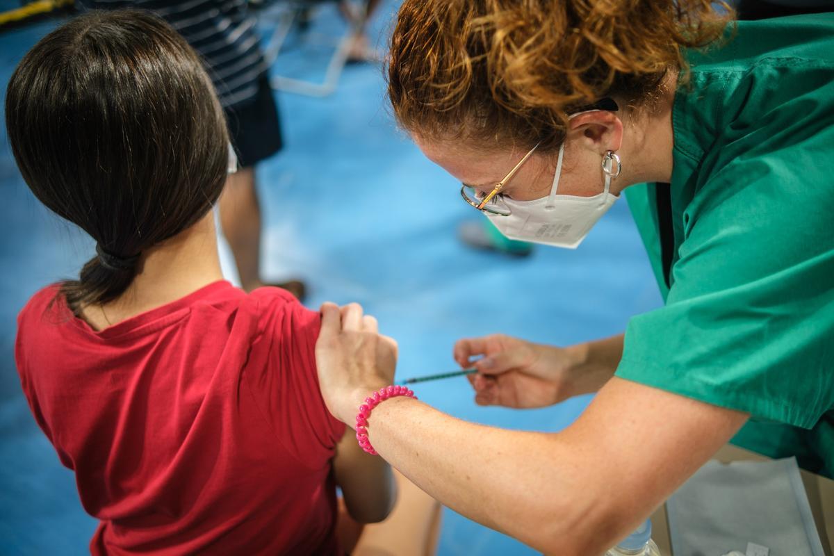 Una sanitaria administra una vacuna contra la Covid a una niña.