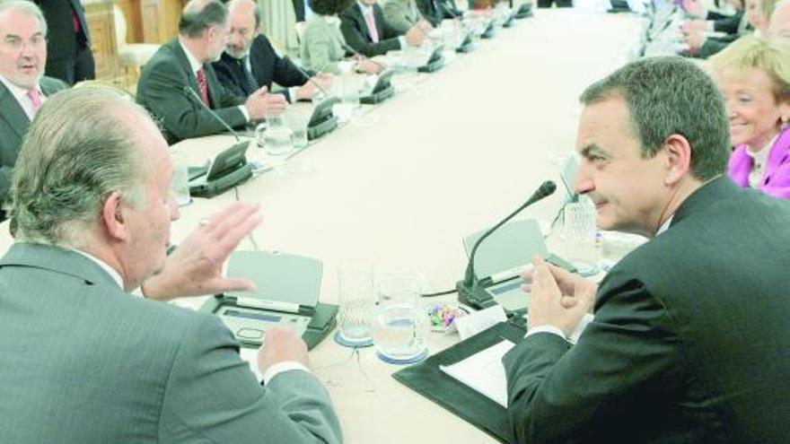 El Rey conversa con el presidente Zapatero antes de iniciar el Consejo de Ministros que ayer presidió en la Zarzuela.