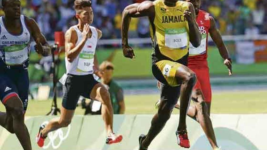 Bolt, en primer término, a la derecha, durante su serie en los 100 metros.