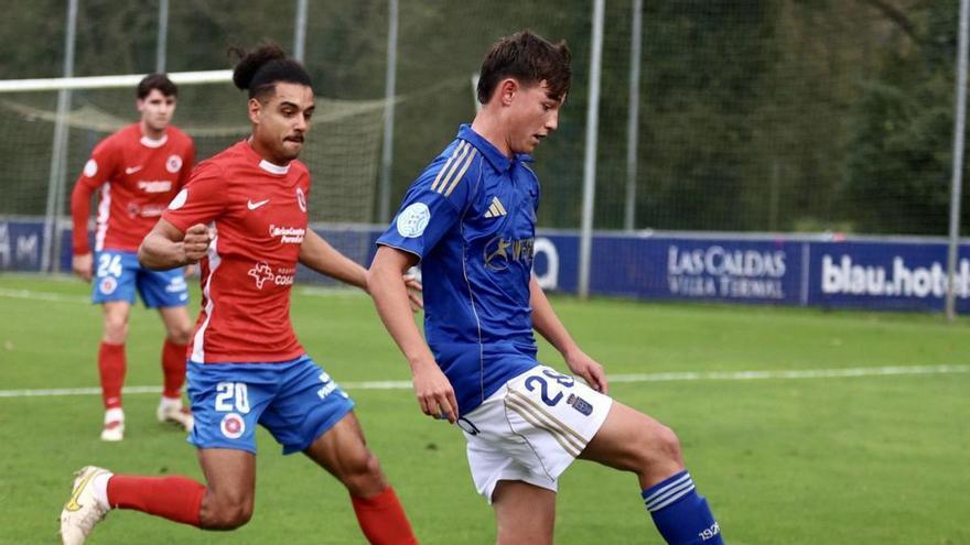 Enzo Pérez controla el balón bajo la atenta mirada de Viti, ayer, en El Requexón. | IRMA COLLÍN