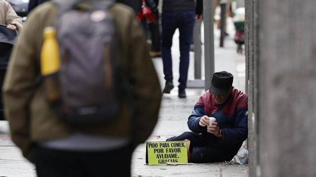 Un hombre pide ayuda en la calle.