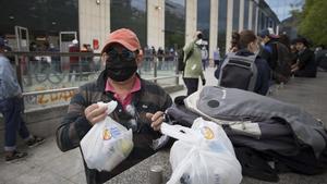 Un hombre recoge bolsas de comida que distribuye el Banc dels Aliments.