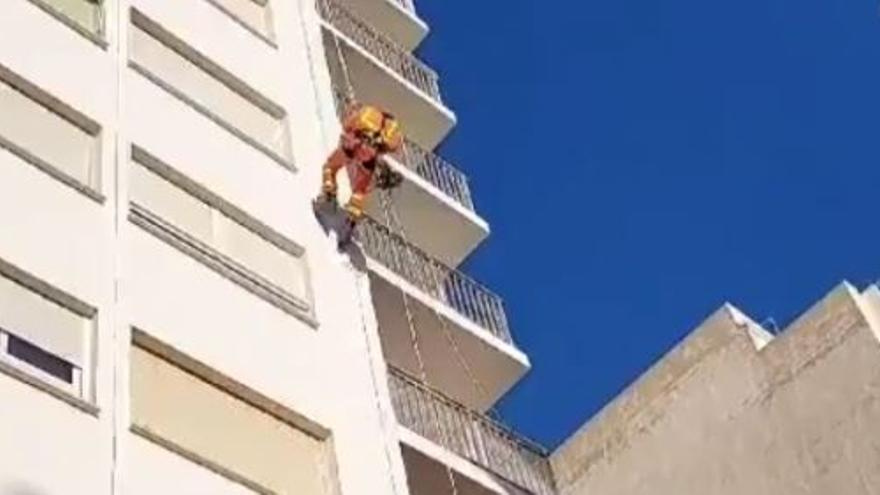 Un bombero desciende haciendo rápel por una finca.