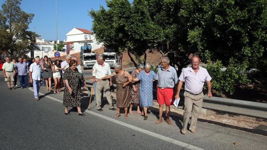 Un grupo de vecinos de la parte alta de la Mosca, el pasado lunes, se dirige a la nueva parada del autobús por los carriles de acceso a la autovía.