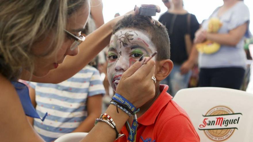 Desde la izquierda, actividad de pintacaras, «Kike Suárez» y Alfonso Ramos, pregonero de las Fiestas de Santiago. |  | LNE