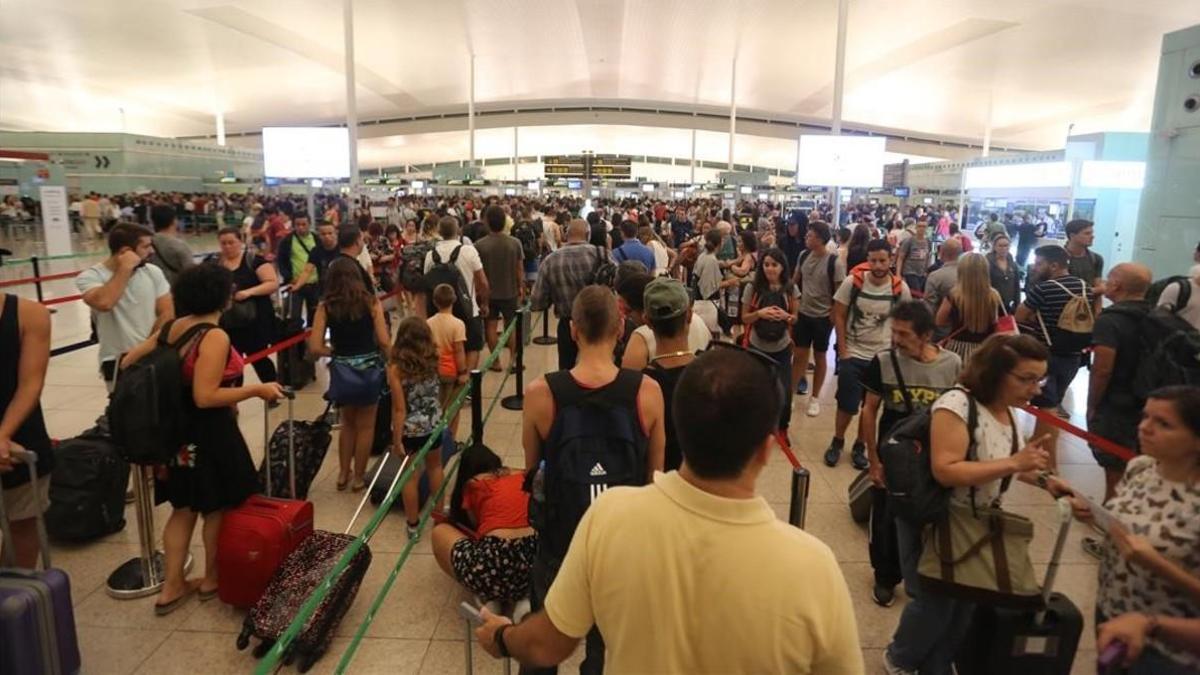 Aglomeraciones de pasajeros en el control de seguridad del aeropuerto de Barcelona.