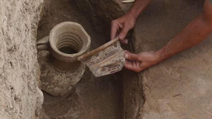 Uno de los arqueólogos del equipo de la UA muestra los restos de ánfora y tinaja encontrados.