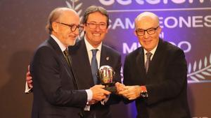 Antonio Brufau recibe el Casco de Oro de manos de Carmelo Ezpeleta, organizador del Mundial de motociclismo, y Manuel Casado, presidente de la Federación Española de Motociclismo.