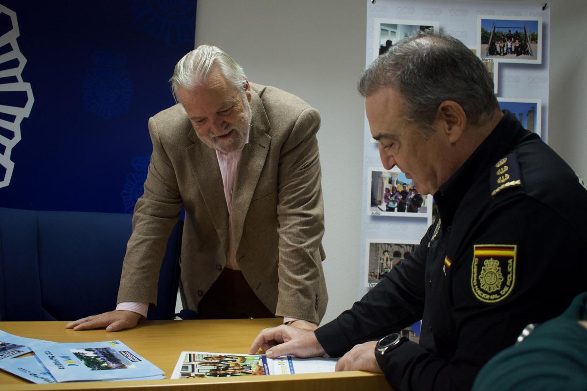 Fabián Cámara con un miembro del cuerpo de Policía Nacional comentando los calendarios solidarios 2026